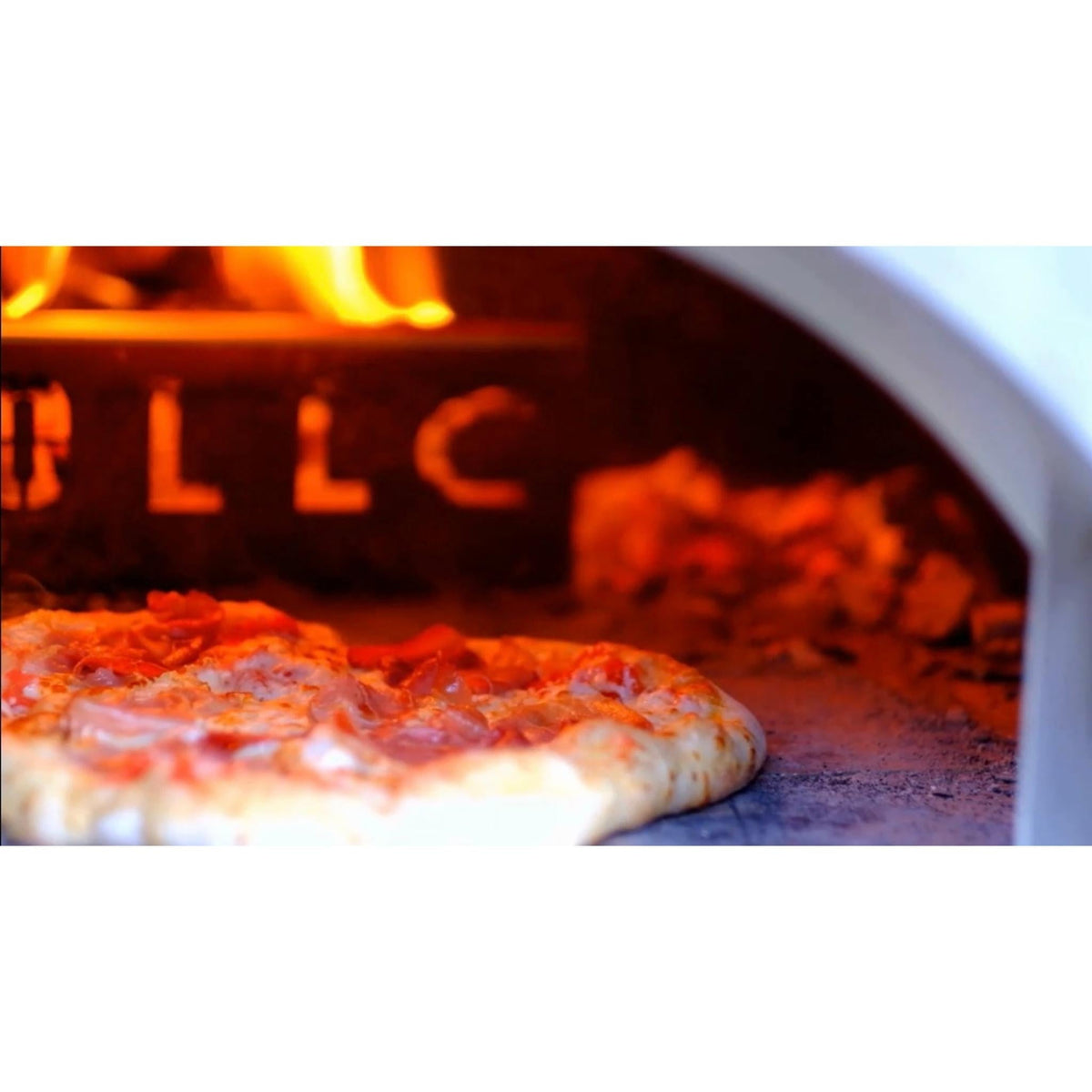 Close-up of a pizza cooking in the WPPO Karma 25 alongside the fire and stainless fire separator