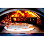 Pizza cooking on the deck of the WPPO Karma 25 with the wood fire burning behind the stainless fire separator